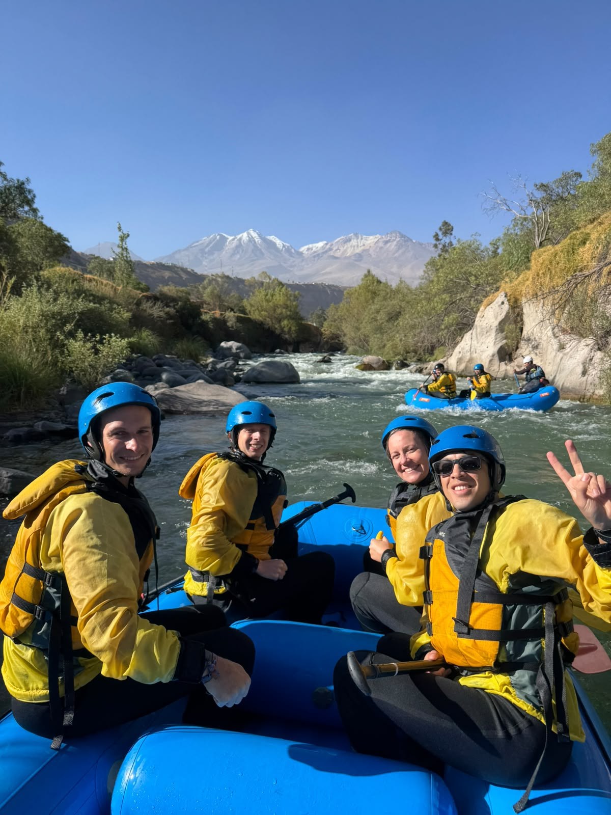 Pasajeros con casco y chaleco en el río Chili, con montañas al fondo