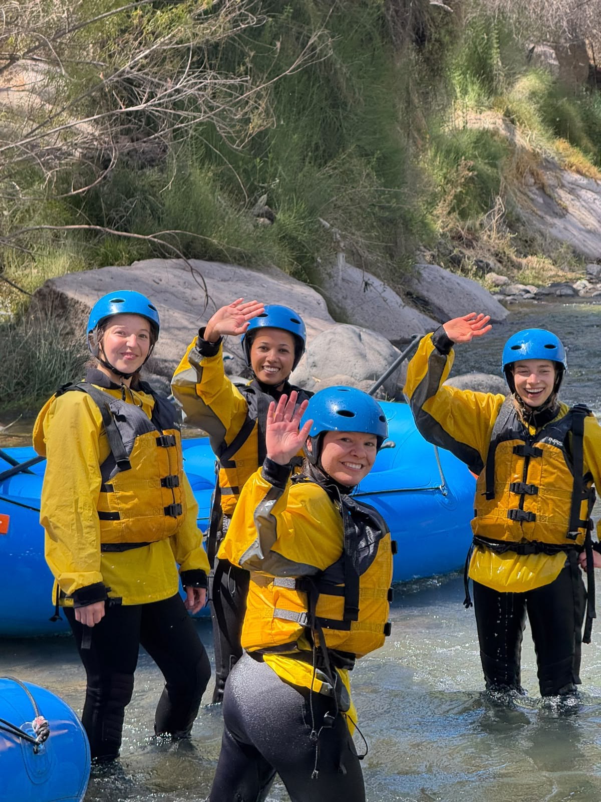 Participantes con equipamiento de rafting saludando